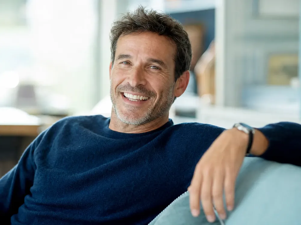 An approachable man in his forties smiling after restorative dental work